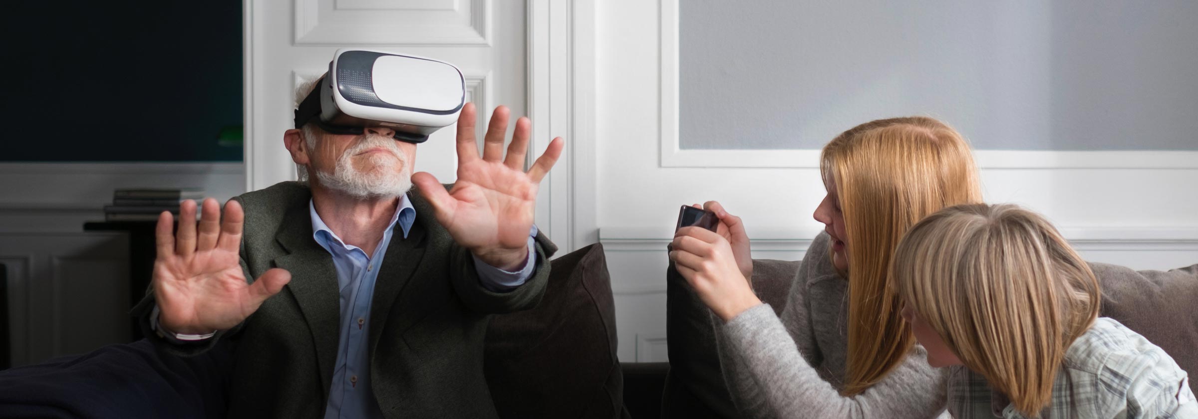 Family introducing grandfather to virtual reality technology